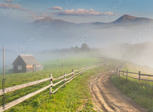Photo: Beautiful summer landscape in a mountain village. Foggy morning Beautiful summer landscape in a mountain village. Foggy morning