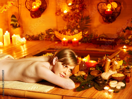 Photo: Woman getting massage in bamboo spa. Woman getting massage in bamboo spa.