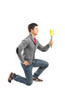 A male kneeling and holding a daffodil flower