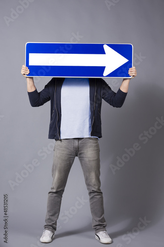 Photo: Man holding horizontal direction arrow sign. Man holding horizontal direction arrow sign.