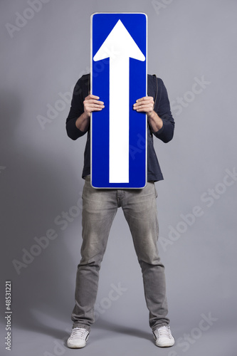 Photo: Man holding vertical direction arrow sign. Man holding vertical direction arrow sign.