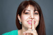 Photo: Smiling woman with finger on lips Smiling woman with finger on lips