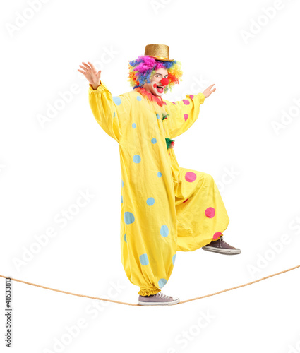 Photo: Full length portrait of a happy male clown walking on a rope Full length portrait of a happy male clown walking on a rope