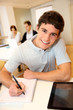 Portrait of student boy writing on notebook