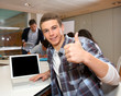Student with laptop showing thumb up
