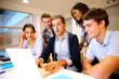 Teacher with students in class working on laptop