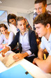 Teacher with students in class working on laptop
