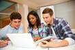 Group of students working on laptop in classroom