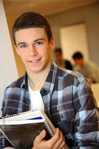 Photo: Student boy in class holding books Student boy in class holding books