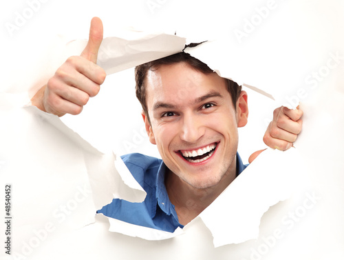 Photo: Man with thumbs up peeping through paper hole Man with thumbs up peeping through paper hole