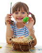 a happy little girl painting easter eggs - white background
