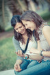 Two Beautiful Women Sending Messages with Mobile
