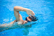 Young man swimming the front crawl in a pool
