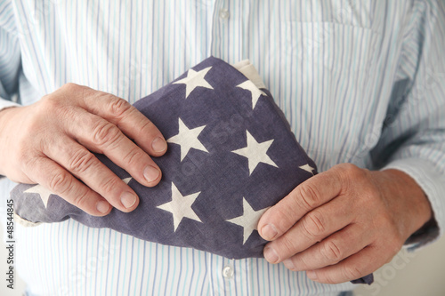 Photo: businessman with an old folded USA flag businessman with an old folded USA flag