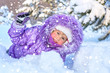 Cheerful little girl playing in a snowy forest.