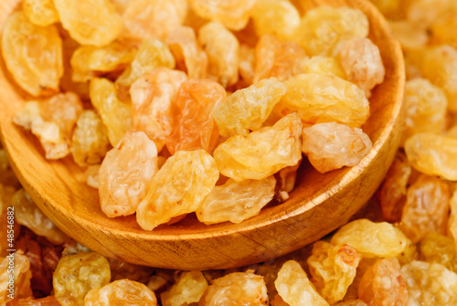 Photo: Golden raisins close- up and wooden spoon, food background Golden raisins close- up and wooden spoon, food background