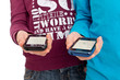 Foto: Zwei Teens mit Smartphone beim Datenaustausch per Bluetooth Zwei Teens mit Smartphone beim Datenaustausch per Bluetooth