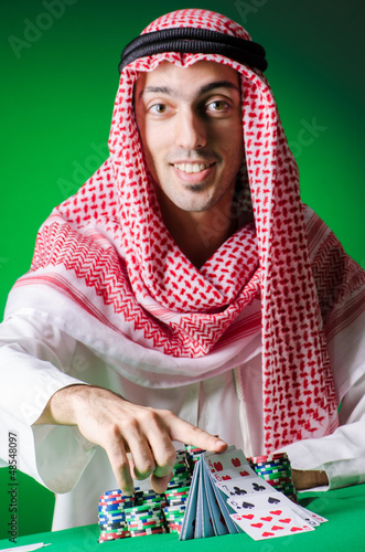 Photo: Arab playing in casino - gambling concept with man Arab playing in casino - gambling concept with man