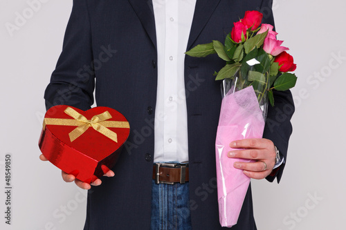 Photo: Man holding flowers and a box of chocolates Man holding flowers and a box of chocolates