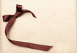 Brown ribbon over vintage gift old paper background