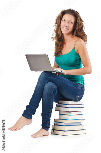 Photo: Student with netbook sitting on books Student with netbook sitting on books