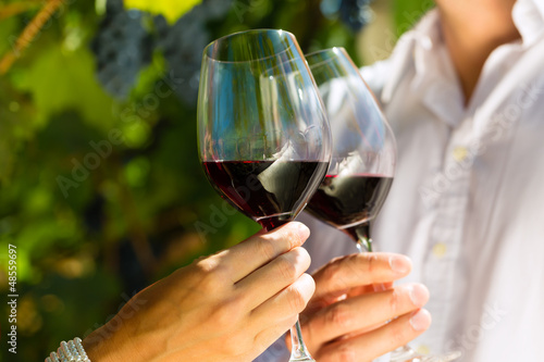 Photo: Woman and man in vineyard drinking wine Woman and man in vineyard drinking wine