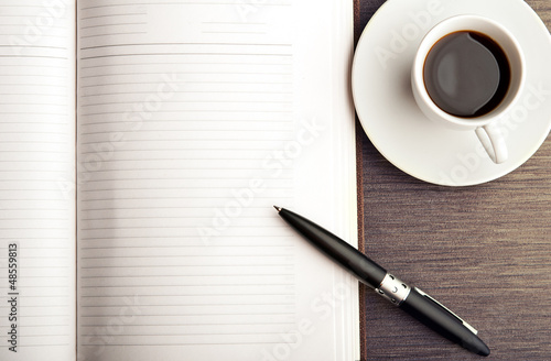 Photo: Open a blank white notebook, pen and coffee on the desk Open a blank white notebook, pen and coffee on the desk