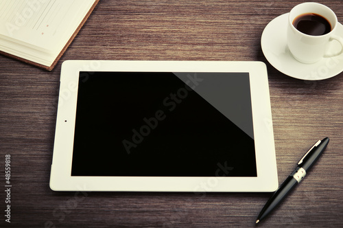 Photo: empty tablet and a coffee on the desk empty tablet and a coffee on the desk