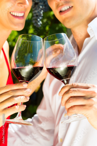 Photo: Woman and man in vineyard drinking wine Woman and man in vineyard drinking wine