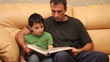 father and son reading a book