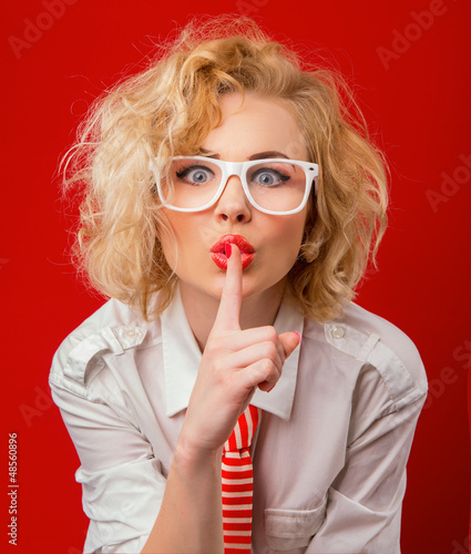 Photo: Woman holding finger on her mouth showing sign silence Woman holding finger on her mouth showing sign silence