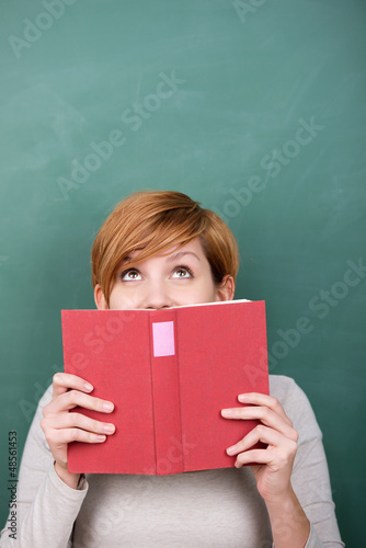 Photo: frau mit buch schaut nach oben frau mit buch schaut nach oben