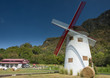 Big windmill of farm house in front of mountain