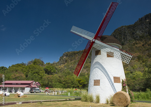 Photo: Big windmill of farm house in front of mountain Big windmill of farm house in front of mountain