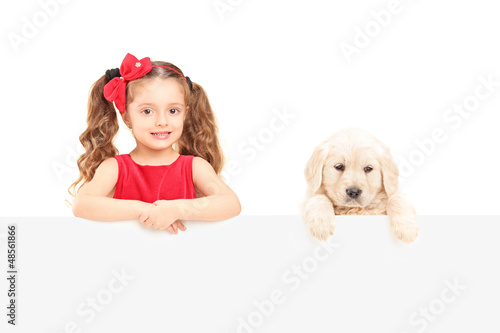 Photo: A small cute girl and labrador retriever posing behind a panel A small cute girl and labrador retriever posing behind a panel
