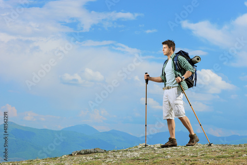 Photo: A young hiker with backpack hiking a mountain A young hiker with backpack hiking a mountain
