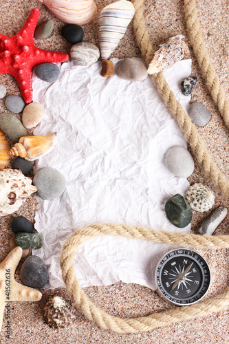 Photo: Blank paper on sand beach with seashells and starfishes Blank paper on sand beach with seashells and starfishes