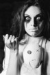 Horror scene: the strange crazy girl with moppet doll and needle