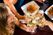 Friends in a very good restaurant clink glasses