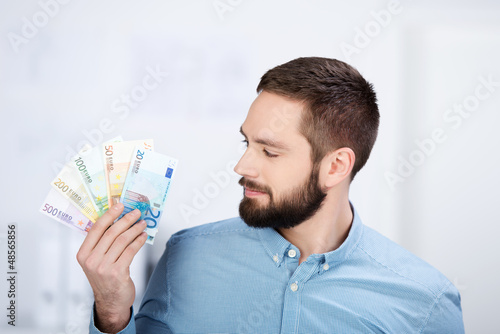Photo: mann schaut auf geldscheine mann schaut auf geldscheine