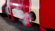 Smoke goes from tube of car with colorful sport design at night
