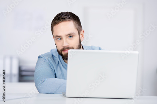 Photo: mann mit laptop im büro mann mit laptop im büro