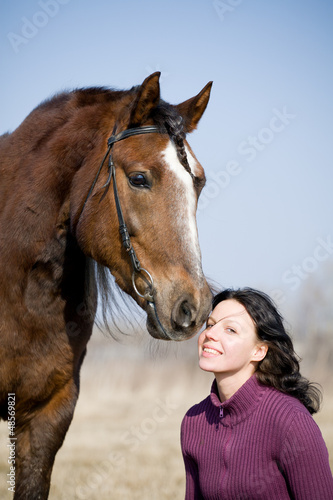 Photo: Young girl and bay horse at spring Young girl and bay horse at spring