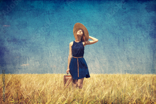 Photo: Lonely girl with suitcase at country. Photo in old color image s Lonely girl with suitcase at country. Photo in old color image s