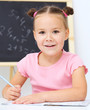 Little girl is writing using a pen