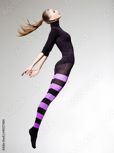 Photo: woman with perfect body jumping dressed in purple striped tights woman with perfect body jumping dressed in purple striped tights