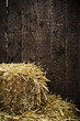 Bale of straw and wooden background