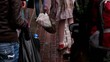 Girl in bloody dress walks by pavement with basket