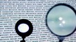 Round magnifying glass moves over text projection on wall