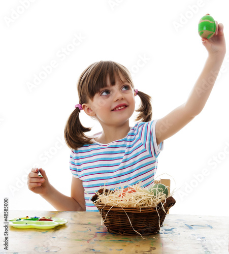 Photo: little girl coloring easter eggs - white background little girl coloring easter eggs - white background